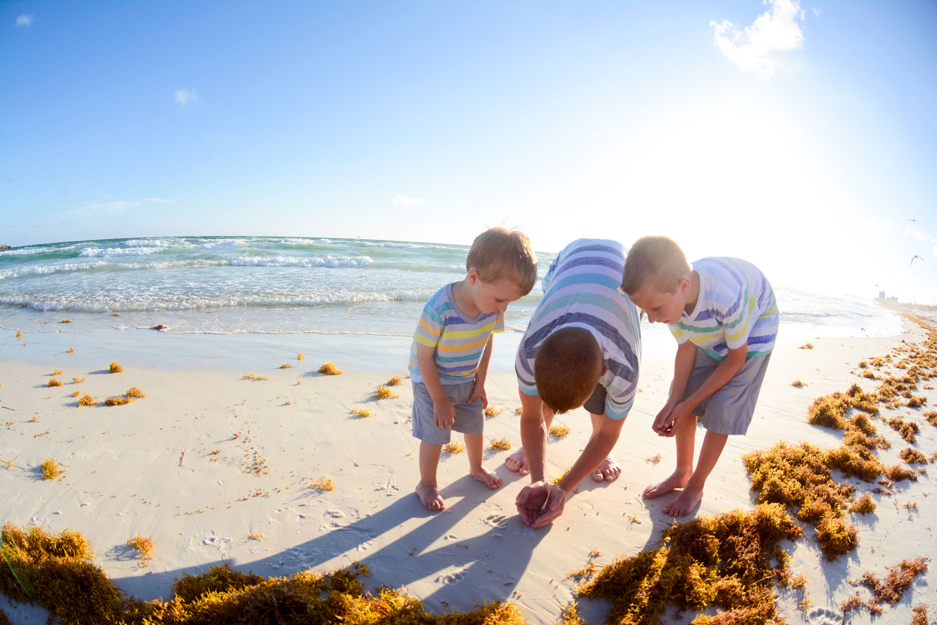 three boys playing on the beach