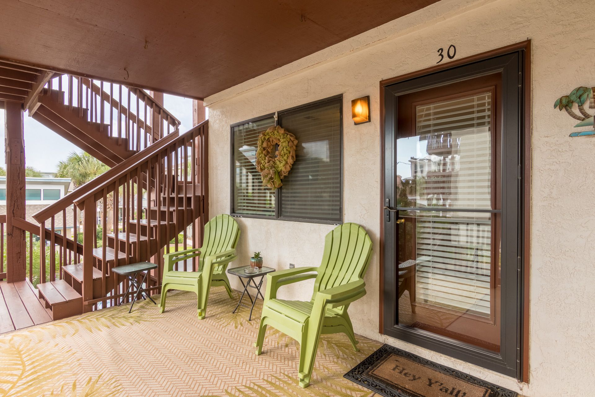 two green chairs on porch by door